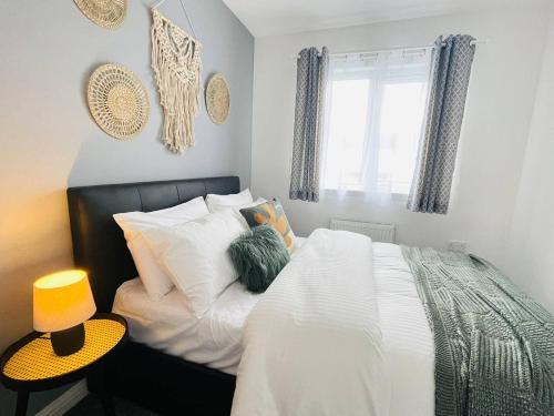 a bedroom with a bed with white sheets and pillows at Elegant 3BR house in Glasgow in Garthamlock
