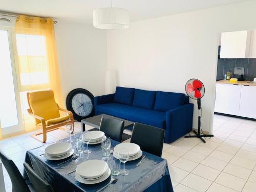 un salon avec une table et un canapé bleu dans l'établissement Beautiful apartment close to Paris and transport, à La Courneuve