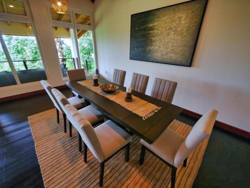 a dining room with a table and chairs at Relax At This Hillside Retreat That Overlooks The Lush Forest And The Caribbean, in West End