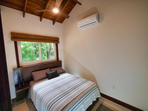 a small bedroom with a bed with a window at Relax At This Hillside Retreat That Overlooks The Lush Forest And The Caribbean, in West End