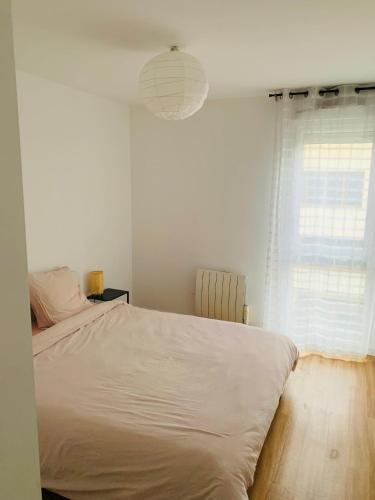 une chambre blanche avec un grand lit et une fenêtre dans l'établissement Beautiful apartment close to Paris and transport, à La Courneuve