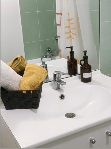 - un lavabo avec 2 bouteilles de savon et un miroir dans l'établissement Beautiful apartment close to Paris and transport, à La Courneuve