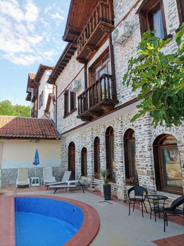 a house with a swimming pool next to a building at Парк - Хотел Макензен in Melnik