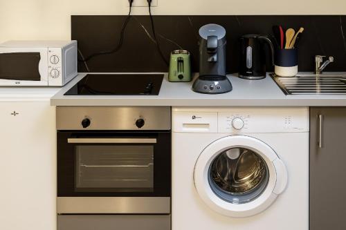 une cuisine avec un lave-linge et un micro-ondes dans l'établissement Charmant et paisible duplex à gare Rennes, à Rennes