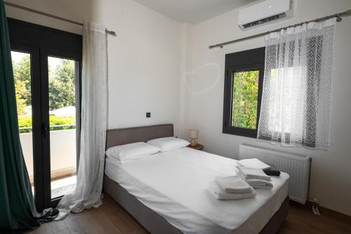 a bedroom with a bed with white sheets and a window at Casa Vacanza in Zakharo