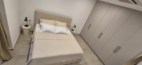 a small bedroom with a bed with white sheets and pillows at Sole di Mare in Opatija