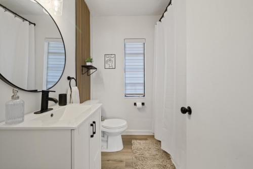 Un baño con lavabo, inodoro y espejo. en La Casita St Pete, en San Petersburgo