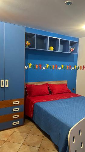 a bedroom with a blue headboard and a red bed at La Casa del Vagabondo in Belvedere