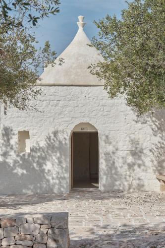 a white church with a door and a roof at Trullo Antonelli in Antonelli