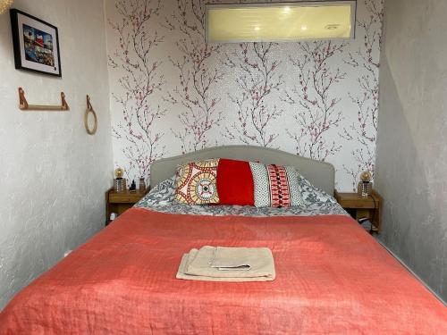 Un dormitorio con una cama con una manta roja. en Charming flat in St Paul village, en Saint-Paul-de-Vence
