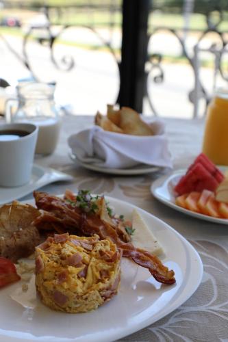 a plate of food with bacon and other foods on a table at Hotel Costa Brava in Manzanillo