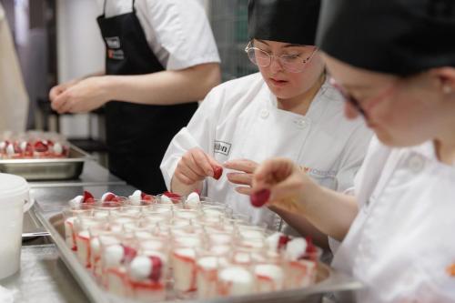 two women in a kitchen preparing food in a kitchen at Foxes Hotel in Minehead