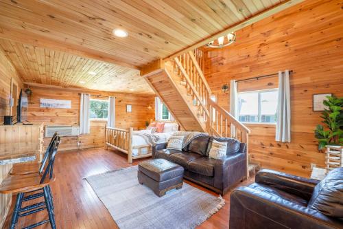 a living room with a couch and a staircase at Cloud 9 Cabin with an indoor pool hot tub & fire pit in Bryant