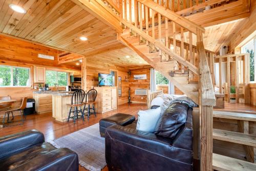 a living room and kitchen in a log cabin at Cloud 9 Cabin with an indoor pool hot tub & fire pit in Bryant