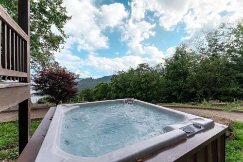 a hot tub on a deck with a view of the mountains at Big Time Hill Cabin with an indoor pool hot tub & great views in Bryant