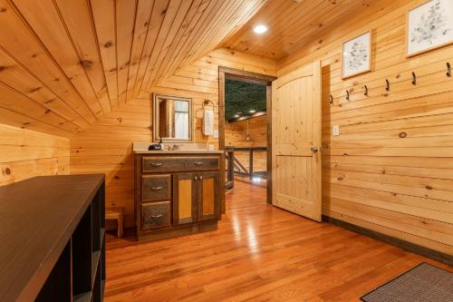 a kitchen in a log cabin with wooden walls at Big Time Hill Cabin with an indoor pool hot tub & great views in Bryant
