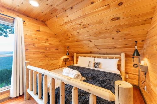 a bedroom with a bed in a log cabin at Big Time Hill Cabin with an indoor pool hot tub & great views in Bryant
