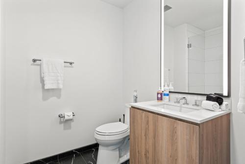a white bathroom with a toilet and a sink at Lux Apts with Lake Views and Top Amenities in Chicago