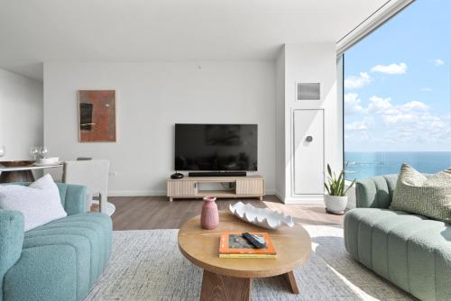 a living room with two blue chairs and a table at Lux Apts with Lake Views and Top Amenities in Chicago
