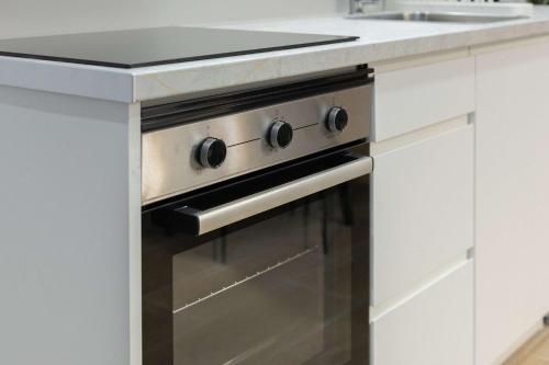 a kitchen with a stove and a sink at Luxury Apartment Oceanografic 9 in Valencia