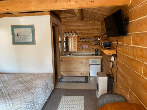 a small room with a bed and a kitchen in a cabin at Burnt Paw in Tok