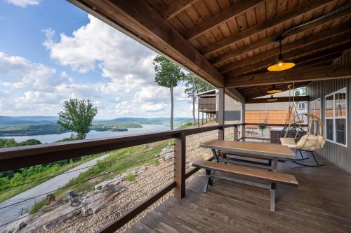 a porch with a picnic table and a swing at Mountain High Cabin with hot tub fire pit & indoor pool in Bryant