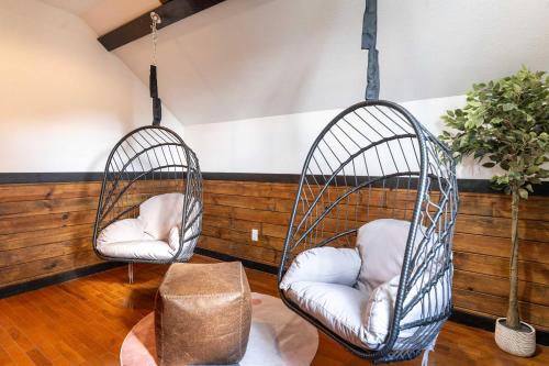two hanging chairs in a room with a table at Mountain High Cabin with hot tub fire pit & indoor pool in Bryant