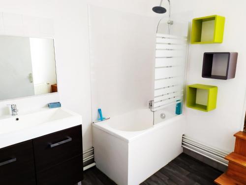 une salle de bain avec un lavabo et une télévision au mur dans l'établissement La Manutention de Saint-Omer, à Saint-Omer