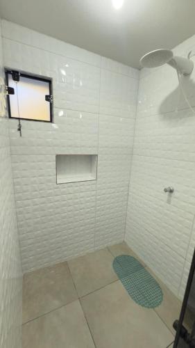 a bathroom with a shower with a window at Chalés Recanto das Rosas in Monte Verde