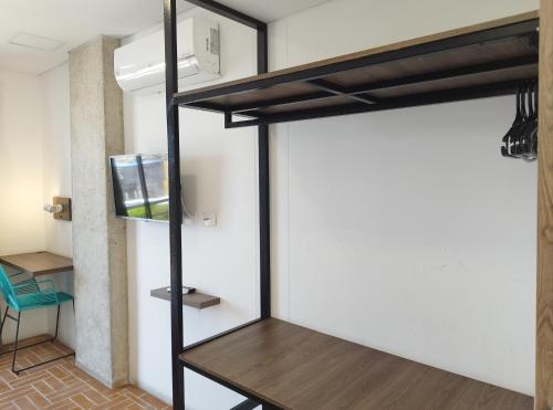 a loft bed in a room with a tv at Hotel Macaw Cúcuta in Cúcuta