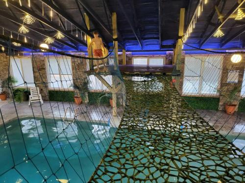 a swimming pool with a net in a building at This is IT Cabin with a hot tub fire pit & indoor pool in Bryant