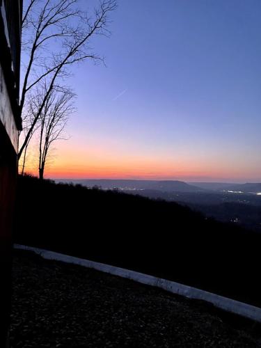 a view of the sunset from the top of a hill at This is IT Cabin with a hot tub fire pit & indoor pool in Bryant