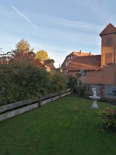 ein Hinterhof mit einem Zaun und einem Springbrunnen im Gras in der Unterkunft GARNI in Hemmingen