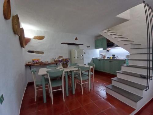 a kitchen with a table and chairs and a staircase at La casa dei mestieri in Lanusei