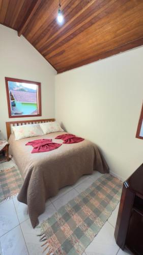 a bedroom with a bed in a room at Chalés Recanto das Rosas in Monte Verde