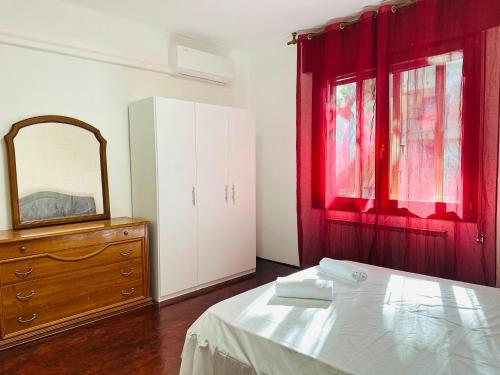 a bedroom with a bed and a dresser and a mirror at Venice Cappucina Guest House in Venice
