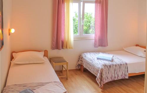 a small room with two beds and a window at 2 Bedroom Gorgeous Apartment In Podgora in Podgora