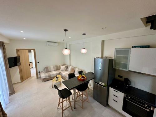 a kitchen and living room with a table and a couch at Nuovo Maistros Villas in Tsoukaladhes