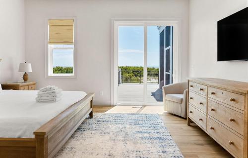 a bedroom with a bed and a dresser and a sliding glass door at 718 Swordfish Road in Fripp Island