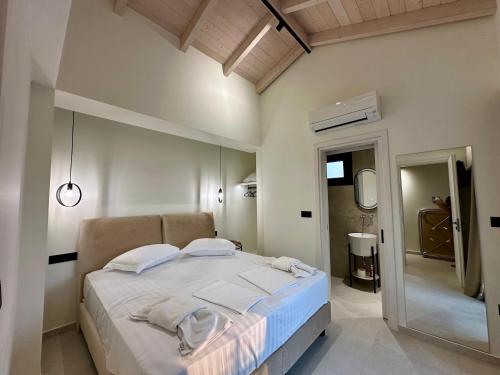 a bedroom with a large bed and a mirror at Nuovo Maistros Villas in Tsoukaladhes
