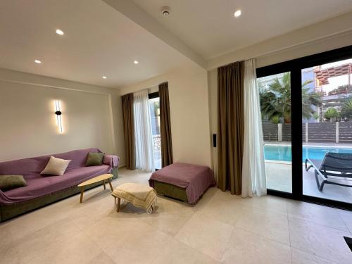 a living room with a purple couch and a pool at Nuovo Maistros Villas in Tsoukaladhes