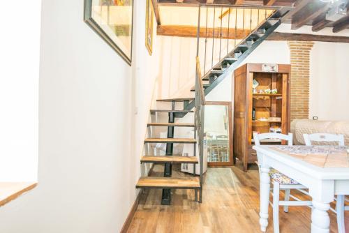 a staircase in a living room with a kitchen and a table at La Casa di Fabiola in Bracciano