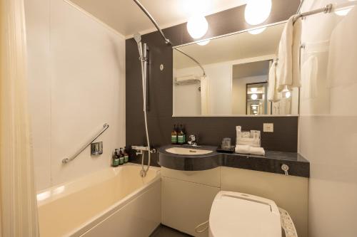a bathroom with a sink and a toilet and a mirror at ANA Crowne Plaza Fukuoka by IHG in Fukuoka