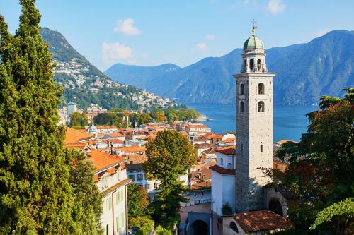 a view of a town with a clock tower at Romantic Terrace With Lake View - Happy Rentals in Ruvigliana
