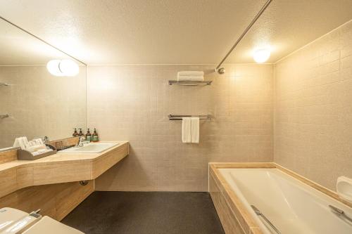 a bathroom with a tub and a sink and a bath tub at ANA Crowne Plaza Fukuoka by IHG in Fukuoka