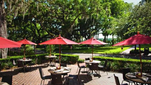 a group of tables and chairs with red umbrellas at Lagoon View 2 Bedroom Wilson Village Home 5037 in Bluffton