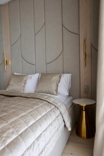 a bedroom with a bed and a side table at Luksusowy apartament Infinity Chill Baltic Spa in Międzyzdroje