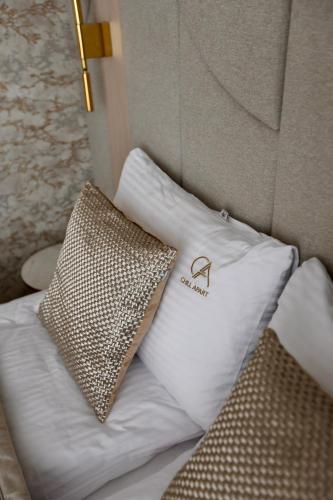 a pillow with a monogram on it sitting on a bed at Luksusowy apartament Infinity Chill Baltic Spa in Międzyzdroje