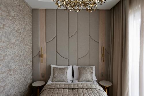a bedroom with a large bed and a chandelier at Luksusowy apartament Infinity Chill Baltic Spa in Międzyzdroje