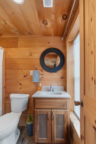 a bathroom with a toilet sink and a mirror at Barndominium at Paradise Pointe in Bryant